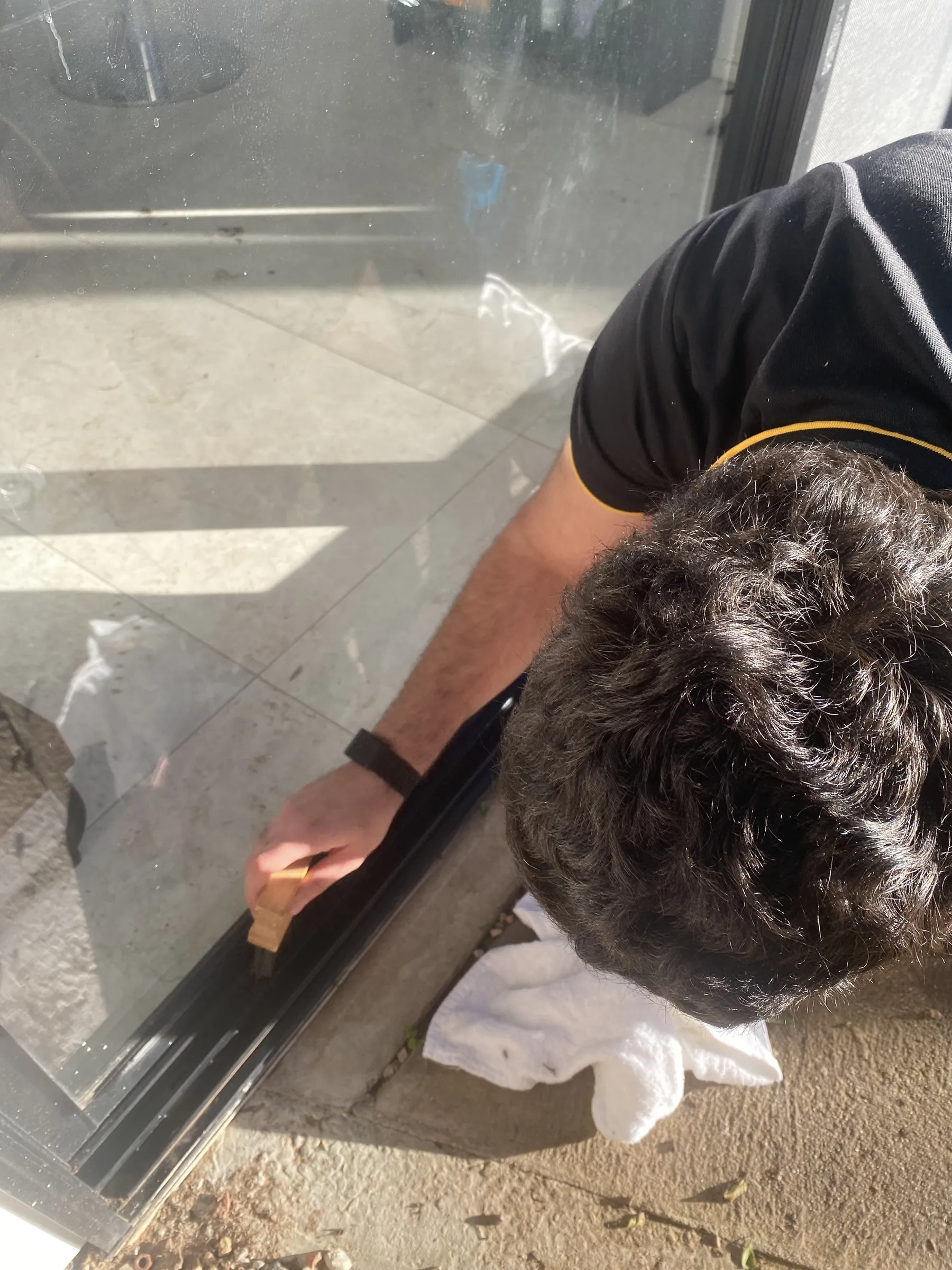 Cleaning a sliding-door track at ground level